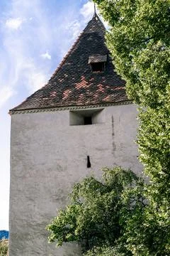 View of a stone wall with a small window near an ancient castle Stock Photos
