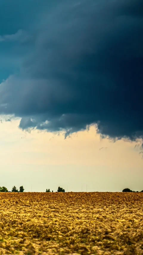 View of storm clouds over a plowed field in Latvia. Stockbeeldmateriaal 339951587