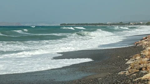 View of storm waves crashing onto rocky beach against distant coastline. Stock Footage 341613062