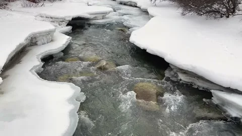View of a stormy mountain small river in the snow Stock Footage 232653407