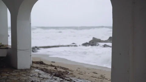 View of the stormy sea through the white arches of a small town. Watching the Stockbeeldmateriaal 124483679