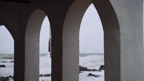 View of the stormy sea through the white arches of a small town. Watching the Stock Footage 124483944