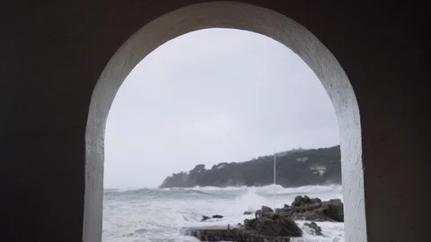 View of the stormy sea through the white arches of a small town. Watching the Stock Footage 124484483