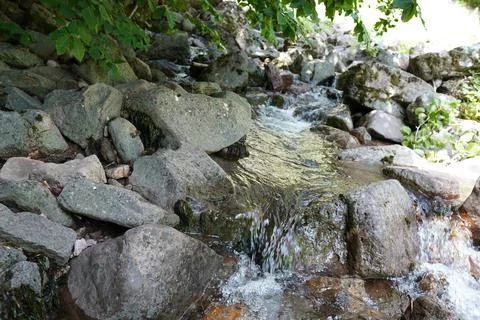 View of streambed and blue sky between natural cliffs Stock Photos