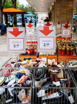 View from the street of multiple clothing objects from sale in front of Muller Stock Photos