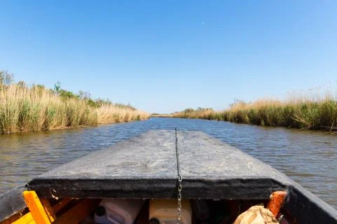 View of the stubble fields while crossing the river on a wooden boat Stock Photos