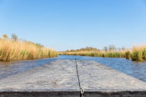 View of the stubble fields while crossing the river on a wooden boat Stock Photos