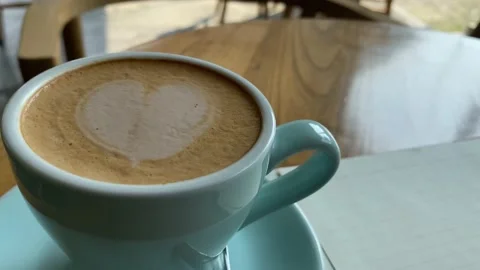 View of study and work at the cafe. a cup coffee with an open book on the wooden Stock Footage 218765486