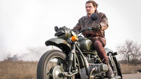 View of stylish cool man in leather jacket riding motorcycle Stock Photos
