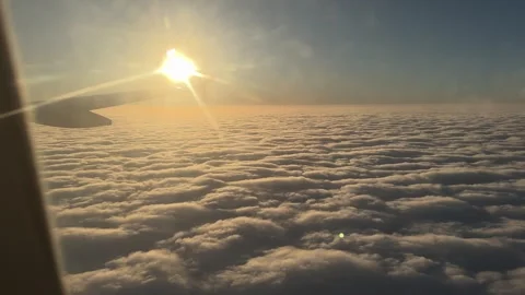 View of sun above thick clouds from airplane window Stock Footage 262365243