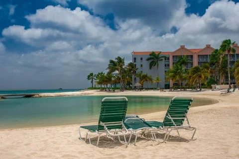 View on the sun bed on the sandy beach and turquoise sea in the hotel resort. Stock Photos
