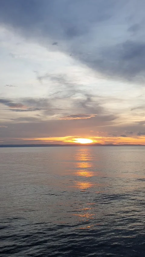 View of the sun between the clouds above the sea Stock Footage 297238202