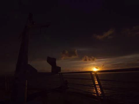 View of the sun setting from the front of a cruise ship Stock Photos