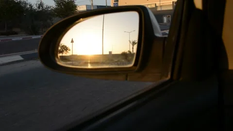 View of the sun at sunset in the rearview mirror of a car Stock-Footage 133650962