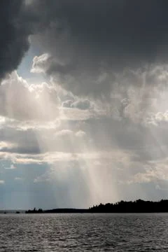 View of sunbeam through clouds over a lake, Lake of the Woods, Ontario, Canad Stock Photos