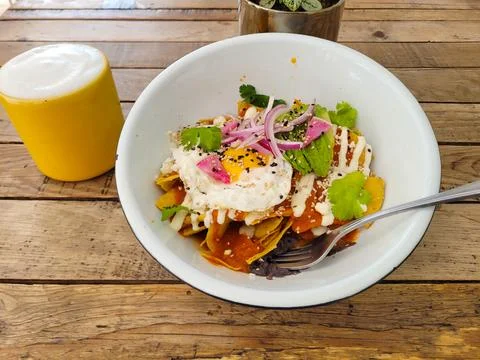 View of Sunny-Side-Up Egg over Spicy Chilaquiles with Crema Stock Photos