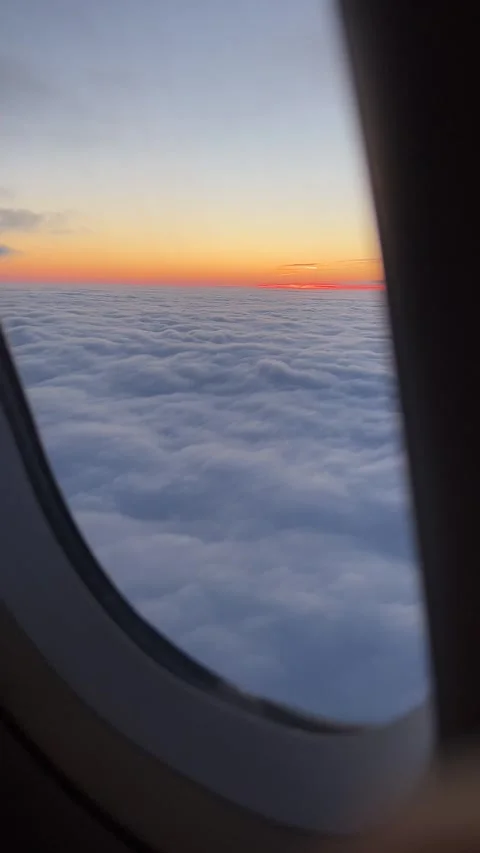 View of sunrise and heavy clouds from airplane window. Vertical video Stock Footage 241023697