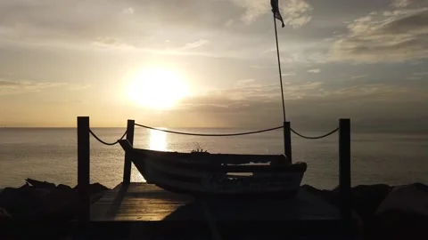 View of a sunset and a boat. Vista de un atardecer y un pequeño bote. Stock Footage