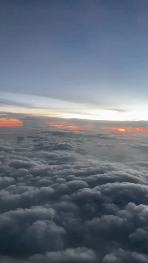 View of the sunset and calm clouds seen from inside the plane Stock Footage 254761596