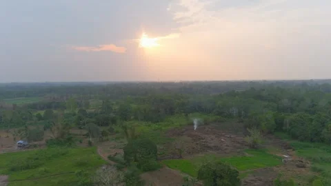 View of sunset and smoke in the middle of a residential area in Kalimantan Stock Footage 253867321