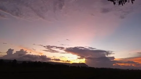 View of the sunset behind the silhouette of thick clouds. Stock Footage 328176748