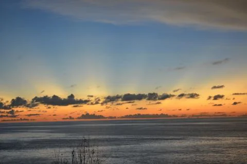 View of the sunset with the orange clouds and blue sky Stock Photos