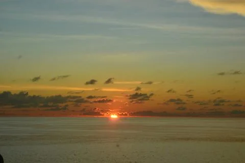 View of the sunset with the orange clouds and blue sky Stock Photos