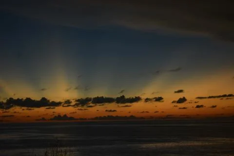 View of the sunset with the orange clouds and blue sky Stock Photos