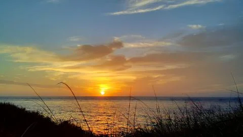 View of the sunset with the orange clouds and blue sky Stock Photos