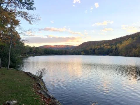 View of sunset over mountain side lake in autumn Stock Photos