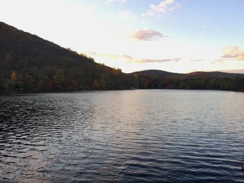 View of sunset over mountain side lake in autumn Stock Photos