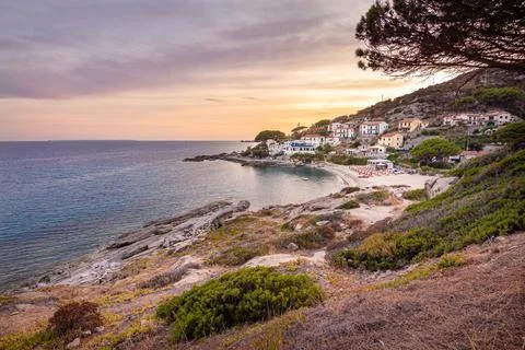 View at sunset over sandy beach of little village Seccheto at Elba Stock Photos