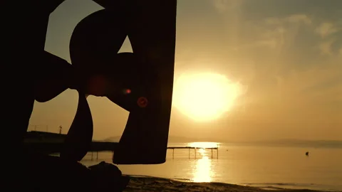 View of the sunset over the sea through the rudder and propeller of a boat. Stock Footage 247464059