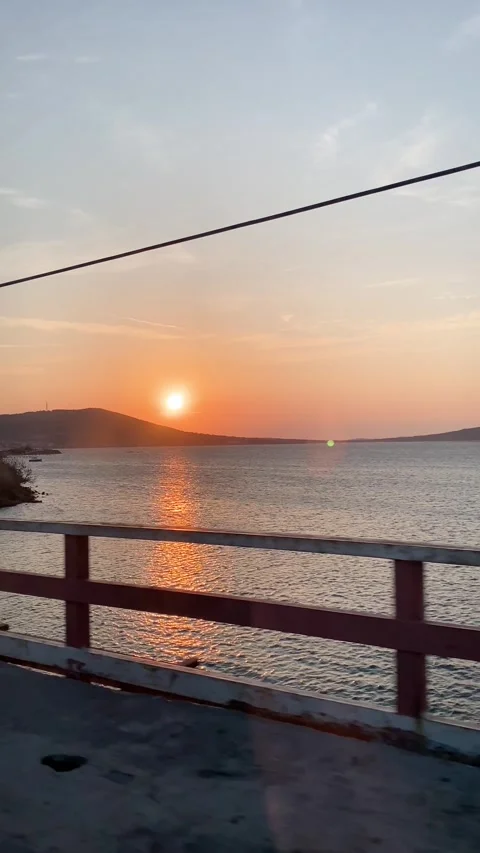 View of sunset over water from bridge through car window Stock Footage 292025863