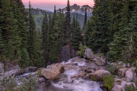 A  view at sunset of a range of mountains from the top of a waterfall, the sk Stock Photos