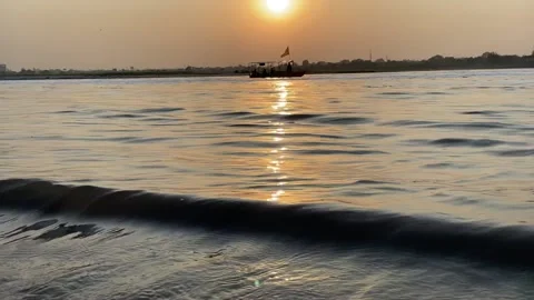 View of sunset from a river bank and a boat passing Stock Footage 171917468