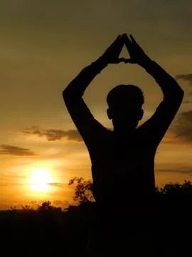 View of sunset with a shadow of a man doing yoga Stock Photos