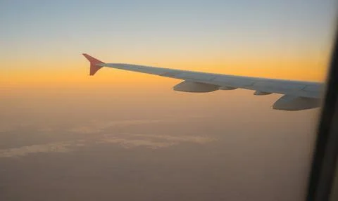 View of the sunset sky from the height of the flight above the clouds from .. Stock Photos