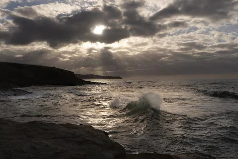 View of a sunset with the sun through the clouds over the Cantabrian Sea. Stock Photos