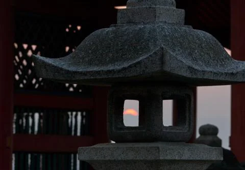 The view of sunset through the fire box (hibukuro) of the stone lantern. Japa Stock Photos