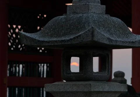 The view of sunset through the fire box (hibukuro) of the stone lantern. J... Stockfoto's