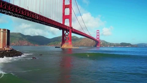 View of Surfers Riding Waves Under Golden Gate Bridge by Aerial Drone Stock Footage 70328260