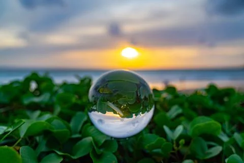 View of sweet sunset on the beach inside crystal ball Stock Photos