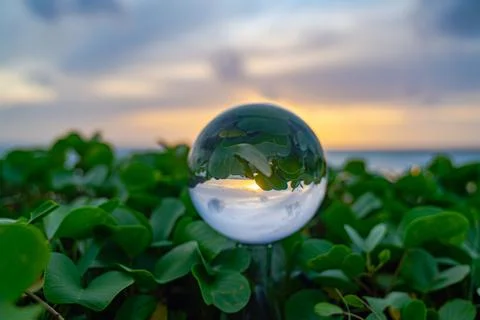 View of sweet sunset on the beach inside crystal ball Stock Photos