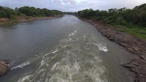 View of swelling river with white foam rapids extending t Stock Footage 342477352