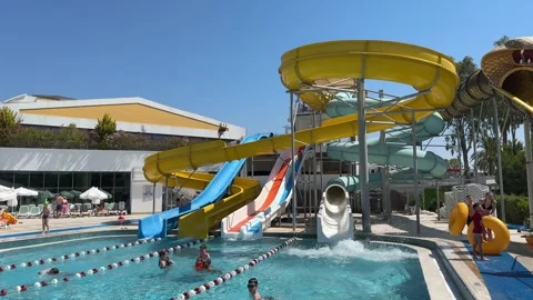 View on swimming pool with turquoise clear water and water slide Stock Footage 310140655