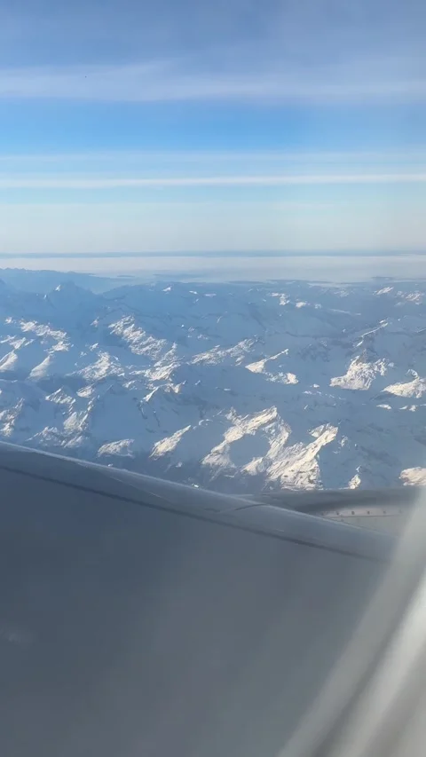 View of the Swiss Alps from the window of a plane Stock Footage 303956945