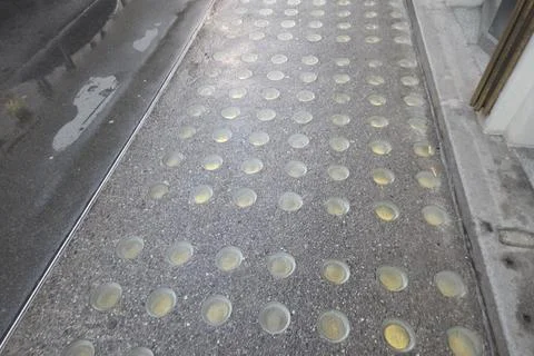 View of a tactile paving surface with rounded bumps, designed for accessibili Stock Photos