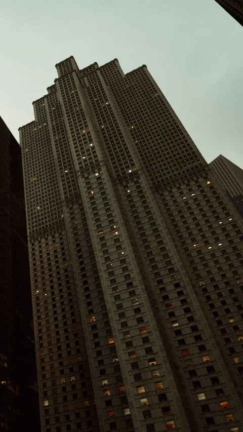 View of a tall building during dusk with lights on in the windows Stock Footage 339098224
