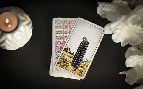 View of tarot card on the table under candlelight, 5 of cups Stock Photos